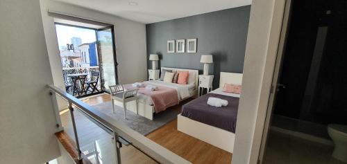 Habitación pequeña con 2 camas y balcón. en 2 Towers Apartment, en Ponta Delgada
