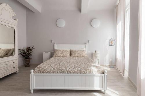 een witte slaapkamer met een wit bed en een spiegel bij Happy Florence San Niccolò Double Apartment in Florence