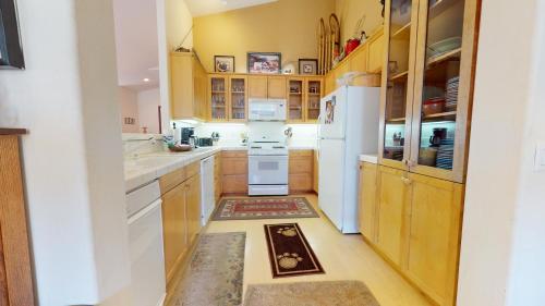 a kitchen with wooden cabinets and a white refrigerator at Snowcreek #760 condo in Mammoth Lakes