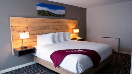 a hotel room with a large bed and two lamps at Mountain Inn at Killington in Killington