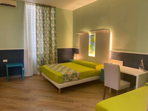 Schlafzimmer mit einem Bett, einem Tisch und einem Schreibtisch in der Unterkunft Porto di mare b&b in Giovinazzo