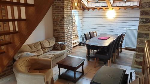 a living room with a table and a couch at Le basecamp des sommets in Stavelot