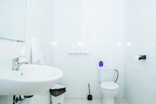 a white bathroom with a sink and a toilet at Onefam Centro in Seville