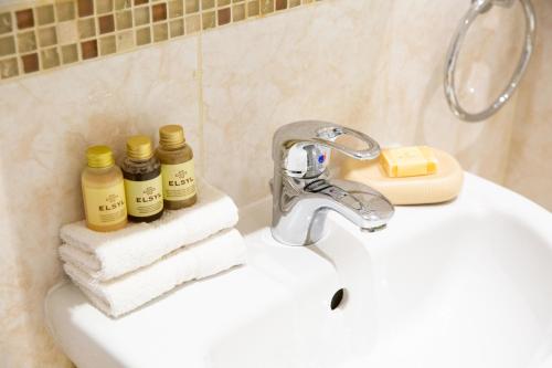 un lavabo de salle de bain avec un robinet et des serviettes dans l'établissement 1-bedroom apartment with balcony, Hoddesdon, à Hoddesdon