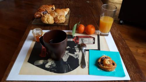 Una bandeja con una taza de café y un plato de pasteles. en Le studio des talents au coeur de Chaumont, en Chaumont