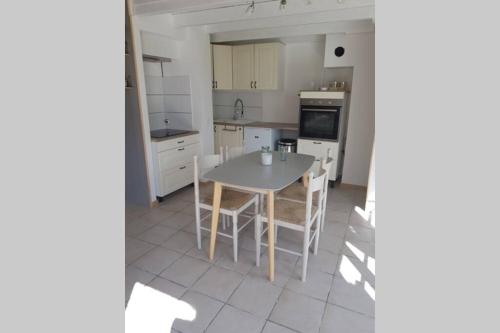 une cuisine avec une table et des chaises dans l'établissement Menthe à l eau, à Lorgues