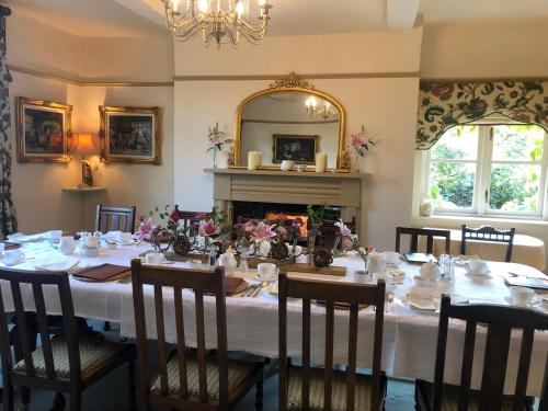 een eetkamer met een tafel en een open haard bij Pickmere Country House in Pickmere