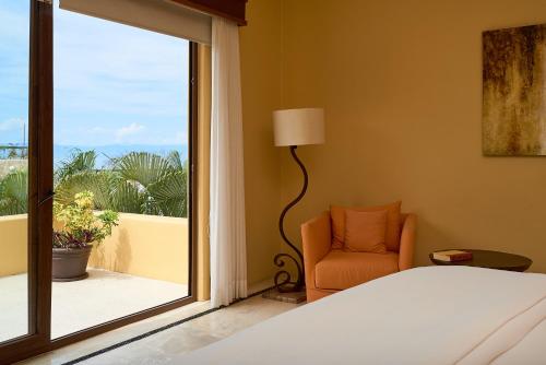 1 dormitorio con 1 cama, 1 silla y 1 ventana en The beach is calling! Big Beach house with all around ocean views in five-star beachfront resort en Cruz de Huanacaxtle