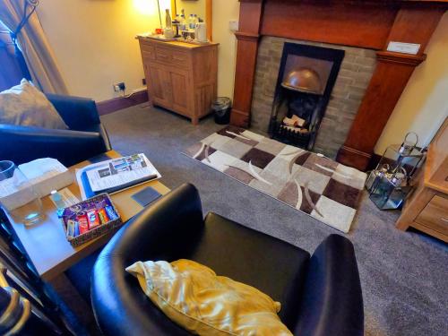 a living room with a fireplace and a table and chairs at Gowanlea Heights in Campbeltown
