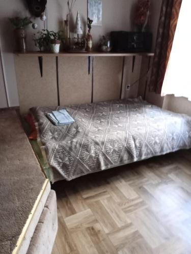 a bed in a room with a wooden floor at Pawi Ogon in Sokołowsko