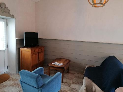 a living room with two chairs and a tv at L'annexe de Gaston in Le Port-des-Barques