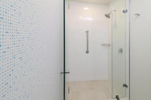 um chuveiro com uma porta de vidro na casa de banho em Holiday Inn Express Guadalajara Iteso, an IHG Hotel em Guadalajara