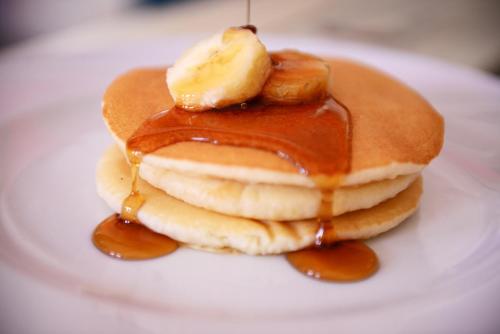a white plate topped with pancakes covered in syrup at Batey Hotel Boutique in Boca Chica