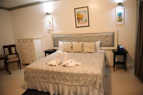 a bedroom with a bed and a dresser at Batey Hotel Boutique in Boca Chica