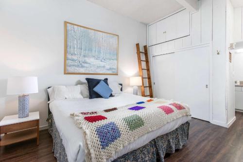 a bedroom with a bed with a crochet blanket on it at Shadowbrook 302 in Snowmass Village