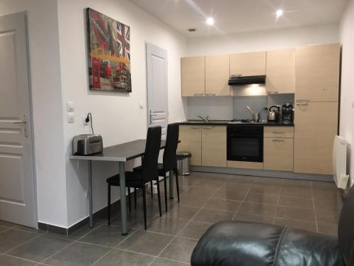 une cuisine et un salon avec une table et des chaises dans l'établissement Appartement la Gare, à La Tour-du-Pin