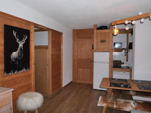 a room with a kitchen with a deer painting on the door at La Belle Etoile in Manigod