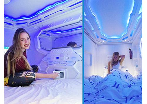 a woman laying on a bed in a room with lights at Capsule24 in Incheon