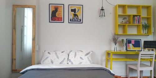 a bedroom with a bed and a yellow desk at Sophie Studio in Da Lat