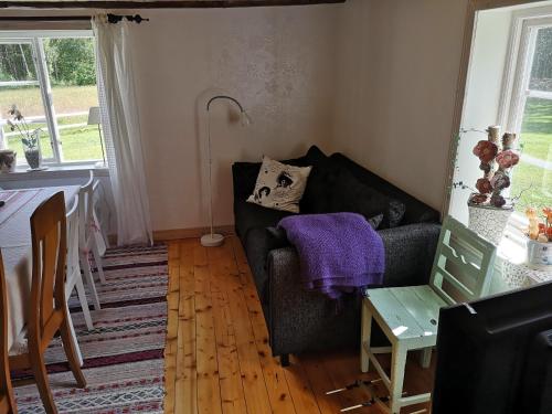 a living room with a couch and a table at Torpet Norra Lundåsen in Fristad