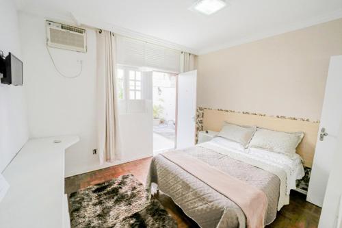 a bedroom with a bed and a window at Casa de Maria Suítes in Recife