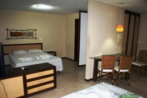 a bedroom with a bed and a table and chairs at Chalet Solar Pipa in Pipa