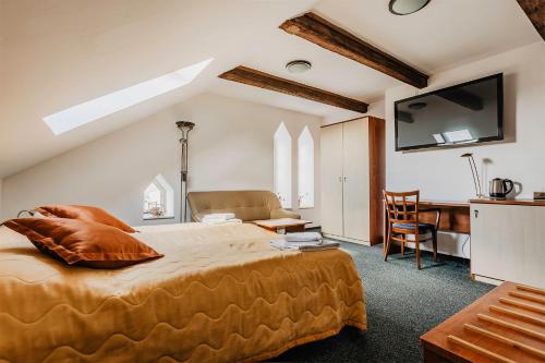 Schlafzimmer mit einem Kingsize-Bett und einem Schreibtisch in der Unterkunft Hotel U Valdické brány in Jičín