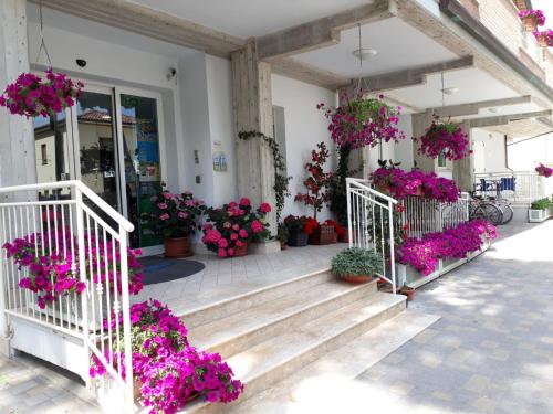 un bâtiment avec beaucoup de plantes en pot et de fleurs dans l'établissement Residence Onda Blu, à Cervia