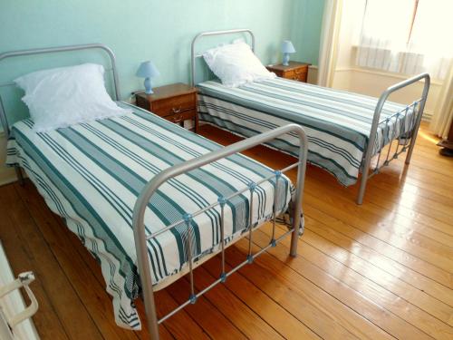 dos camas sentadas una al lado de la otra en una habitación en Meublé de tourisme, en Frasne