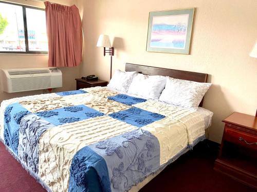 a bedroom with a bed with a blue and white blanket at REGENCY INN in Orlando