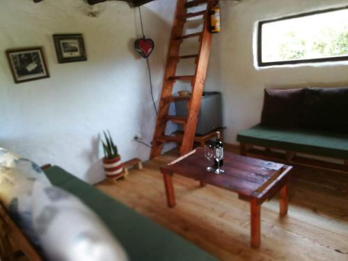 a living room with a ladder and a couch and a table at Jardin Colibri RNT 33633 in Guatavita