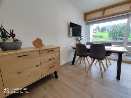 una sala da pranzo con cassettiera in legno, tavolo e sedie di Berghof Apartment Bergwiese Top 31 a Ellmau