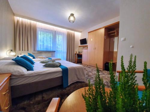 a bedroom with two beds with blue pillows at Gościniec Pod Skrzycznem in Szczyrk