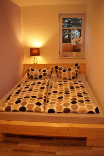 Bett in einem Zimmer mit Fenster in der Unterkunft Gute Laune Hof Klingenthal in Klingenthal
