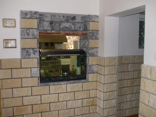a stone tile fireplace in a living room at Penzion Pohoda in Jetřichovice