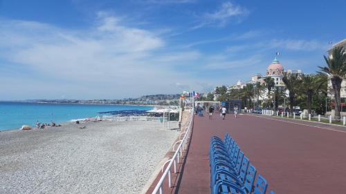 een strand met een hek en mensen op het strand bij Dante Riviera in Nice