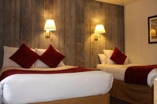 um quarto de hotel com duas camas com almofadas vermelhas em St Moritz Lodge and Condominiums em Aspen