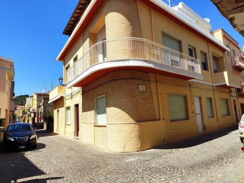 un edificio con un balcone sul lato di B&B 24 Maggio a Carloforte