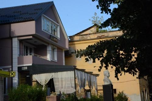 a building with a statue in front of it at Royal Hotel Peshkopi Albania in Peshkopi
