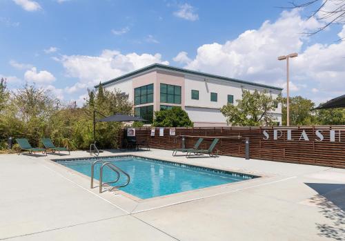a swimming pool in front of a building at Wingate by Wyndham and Williamson Conference Center in Round Rock