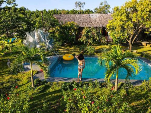 una mujer parada en una piscina con un frisbee en Hamya Hotsprings and Resort, en Quảng Ngãi