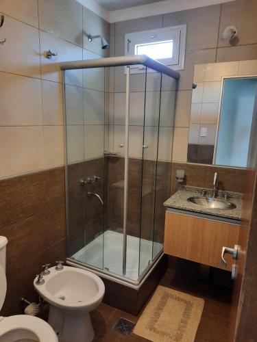 y baño con ducha, aseo y lavamanos. en CALIDO-Departamento 1 dormitorio amueblado excelente ubicacion en Río Cuarto