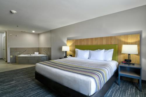 A bed or beds in a room at Country Inn & Suites by Radisson, Oklahoma City Airport, OK