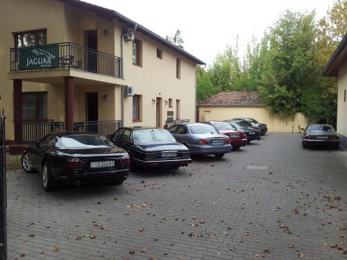 a row of cars parked in front of a building at Balaton Apartmanház in Siófok