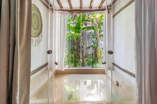 a glass door leading to a window in a room at Hotel Villas Flamingos in Holbox Island