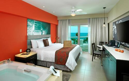 ヌエボ・バジャルタにあるハード ロック ホテル バリャルタ オール インクルーシブのベッドとバスタブ付きのホテルルームです。