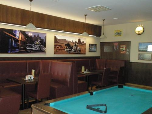 un restaurante con una mesa de billar en el centro en Hotel Le Café, en Pohořelice