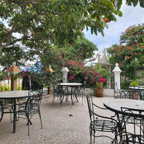 an outdoor patio with tables and chairs and flowers at Perla Maya Hotel in Panajachel