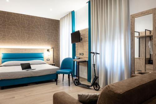 a bedroom with a blue bed and a blue chair at Cuneo Hotel in Cuneo