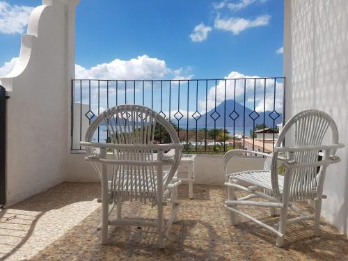 two chairs on a balcony with a view of the ocean at Perla Maya Hotel in Panajachel